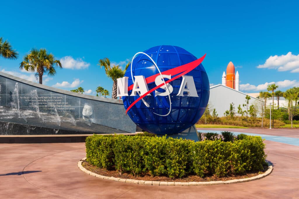 Cape Canaveral, FL, USA: NASA Logo on Globe at Kennedy Space Center Visitor Complex in Cape Canaveral, Florida, USA. To the left is a painting visible of President John F. Kennedy.