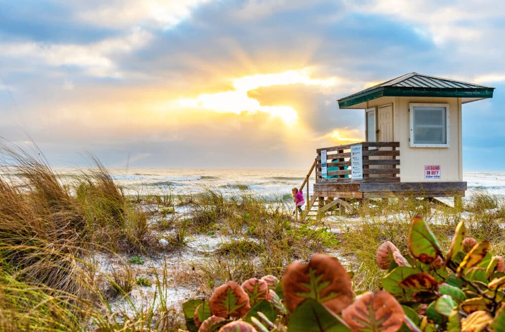 Lido Key Beach Lifeguard Tower at Sunset in Sarasota, FL. A family enjoying the sunset at the beach.