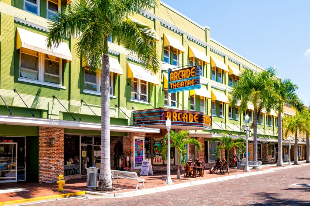 Fort Myers, USA: Florida Gulf of Mexico city street with retro vintage neon sign for Arcade theatre theater building with shops stores