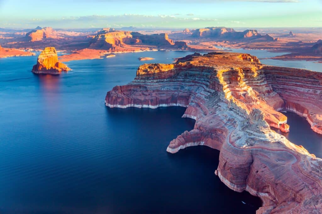 Lake Powell is a reservoir on the Colorado River located in the U.S. states of Utah and Arizona. Small islands stick out of the water.  Landscape under the wing of an airplane