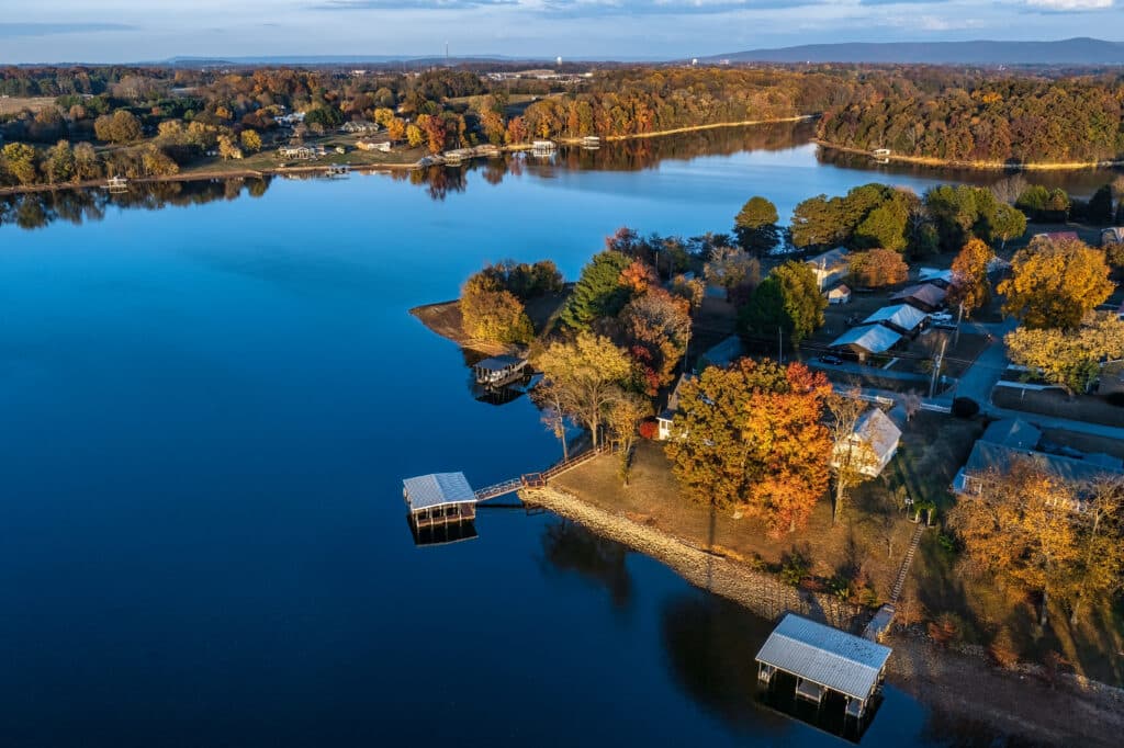Aerial view of waterfront homes, boat docks and beautiful autumn foliage with mountains in the background on Tims Ford Lake in Winchester, Tennessee USA.