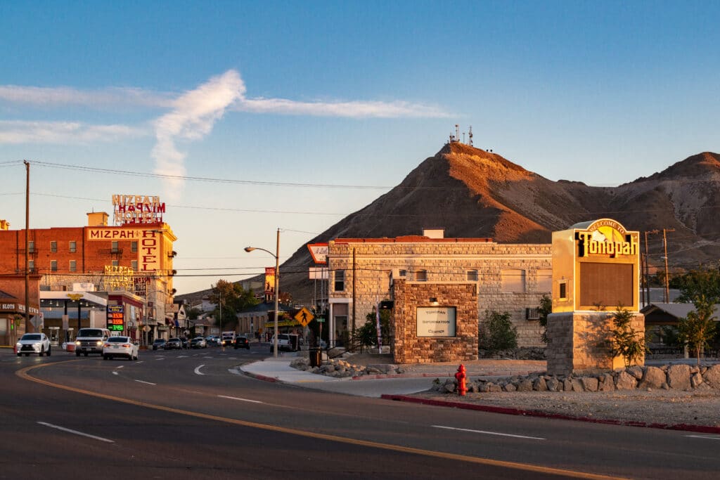 TONOPAH, NEVADA, UNITED STATES. Sunset down main street (Highway 95) featuring historic downtown Mizpah Hotel and Welcome to Tonopah Sign.