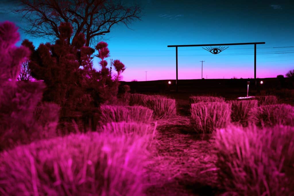 Marfa, Texas eye sign at night infrared style with pink blue sky