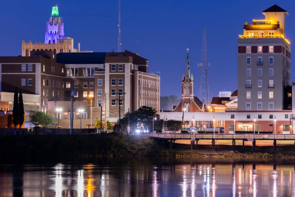 Monroe, Louisiana, USA: Evening lights shine on the historic buildings, skyline and river of downtown Monroe.