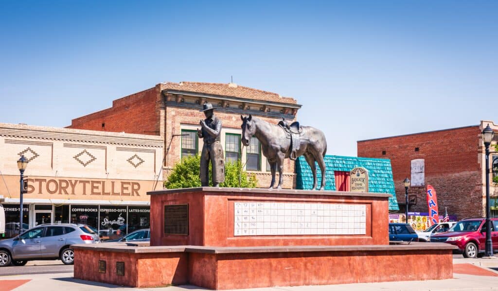 The bronze Soil to Riches statue by Carl Jensen on Broadstreet in Thermopolis Wyoming depicts a pioneer and his horse