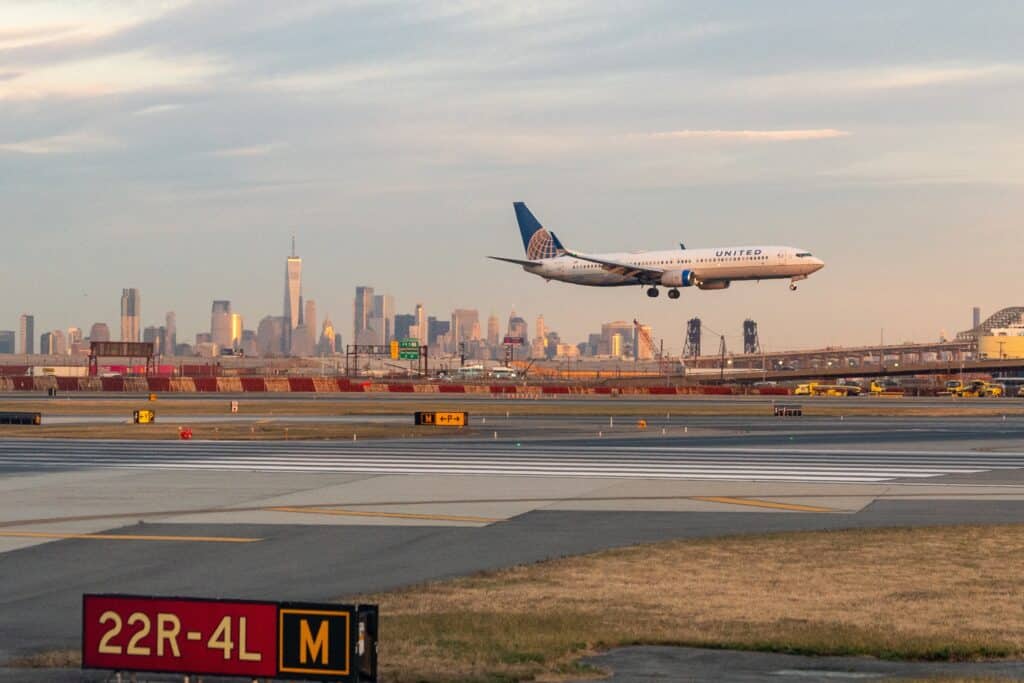 Newark Liberty Airport, Newark, New Jersey, USA - United Airlines Jet landing at Newark Liberty Airport at golden hour with the Lower Manhattan skyline in the background