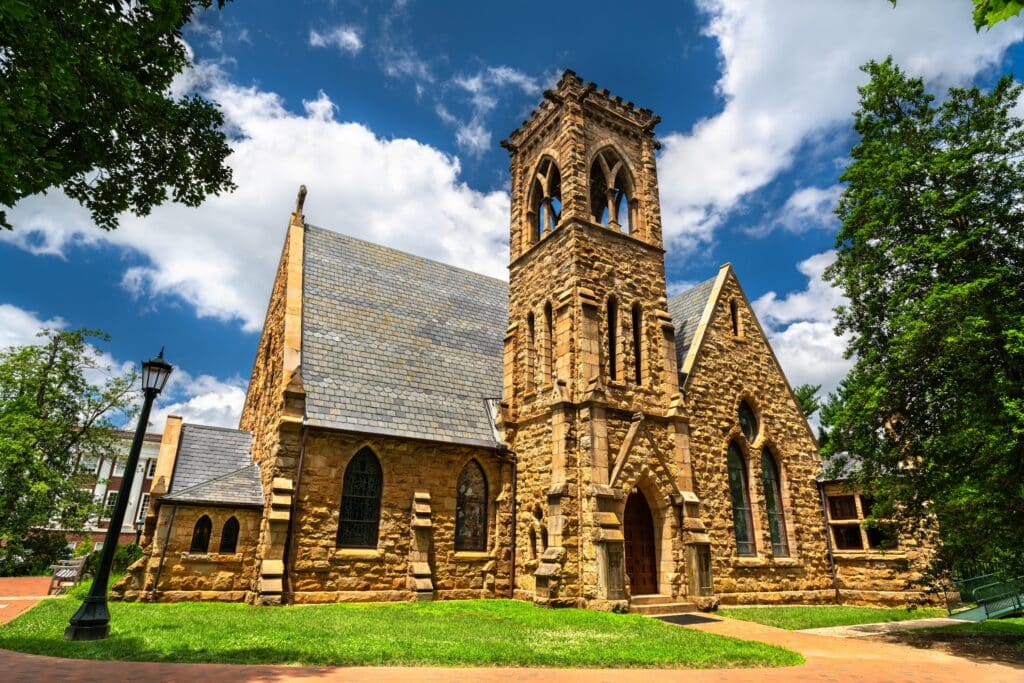 Gothic-style University Chapel on the campus of the University of Virginia in Charlottesville, United States, featuring pointed arches, stained-glass windows and a bell tower surrounded by trees