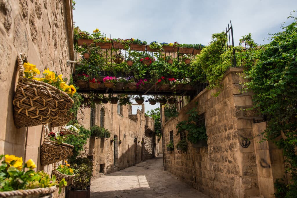 Mardin, Artuklu / Turkey: One of the street from Mardin city center. Stone house and colored flowers on the walls.