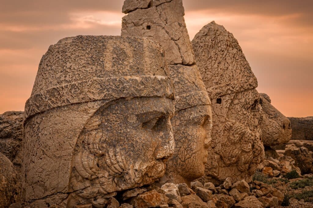 The ancient carved heads of Zeus, Apollo, Hercules and lion at sunset on the east terrace at Mount Nemrut (Nemrut Dağı) an archaeological site of the ancient Kingdom of Commagene in south east Turkey