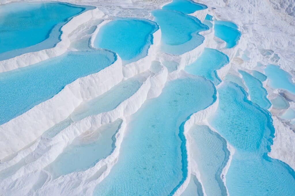 Aerial top view Pamukkale Turkey travertine pools, nature terraces with blue water.