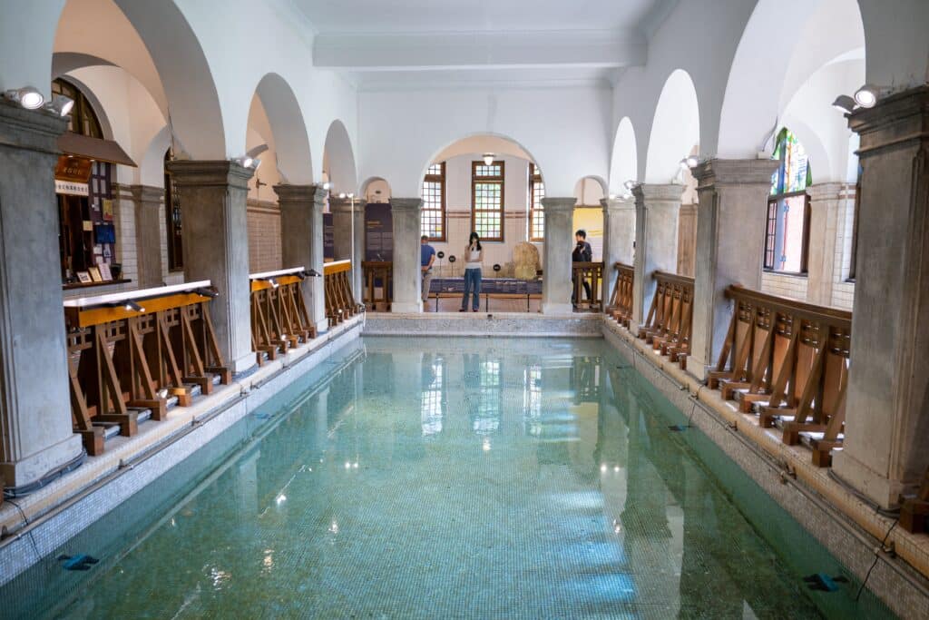 Beitou Hot Springs Museum, a historic 1913 Tudor-style bathhouse with brick-wood façade and Japanese-Western blend, showcases geothermal exhibits amid misty valleys.