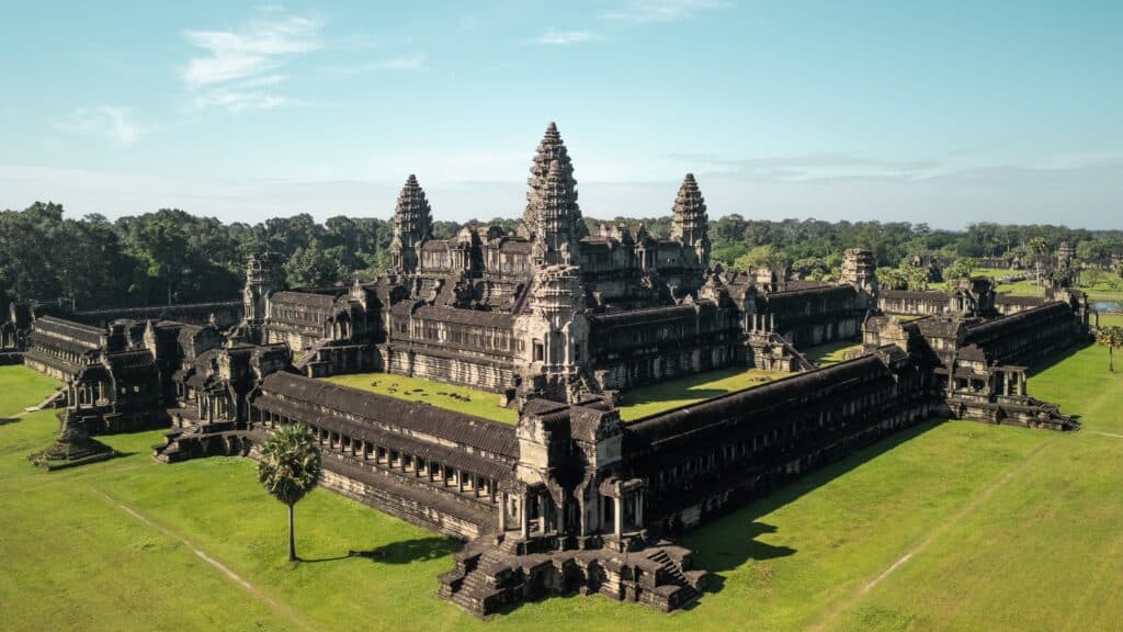 Angkor Wat temple complex aerial drone photo shows symmetrical Khmer towers, galleries and courtyards amid green lawns and jungle. Concept, quality image for editorial, tourism ads and destination use