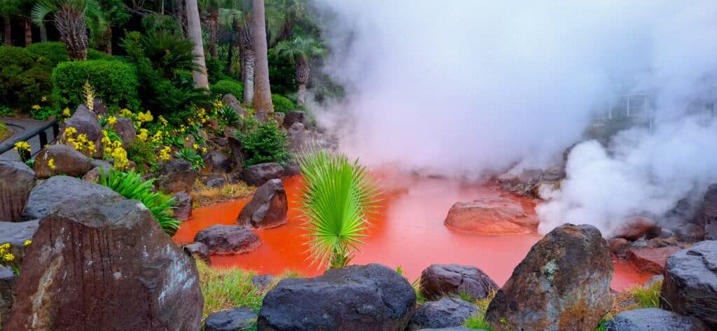 Steam rising from colorful hot springs in Beppu Japan