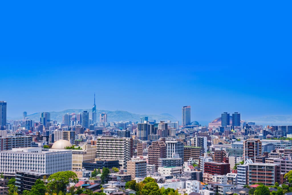 Panoramic view of Fukuoka skyline with modern buildings and surrounding hills