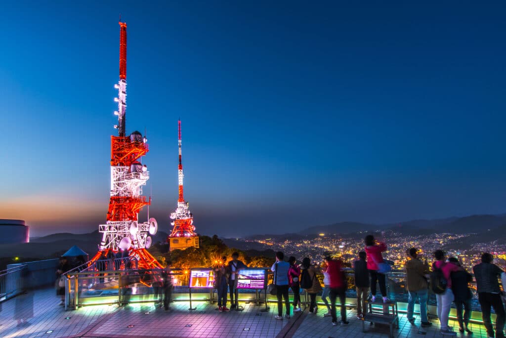 Visitors enjoying panoramic night views from the Mount Inasa observation deck in Nagasaki