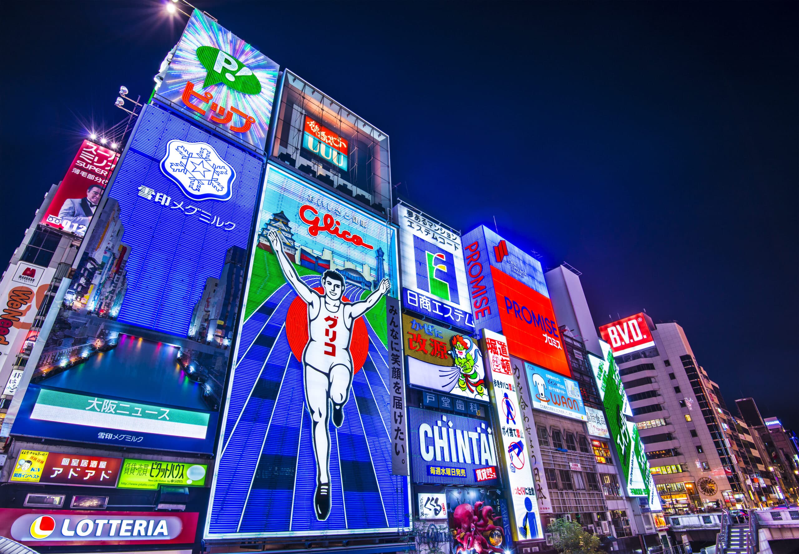 Illuminated Glico Running Man billboard overlooking Dotonbori Canal