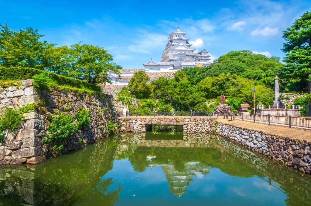 Himeji Castle reflected in the moat on a sunny summer day in Japan