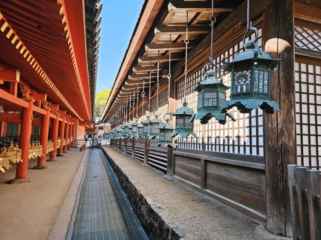 Rows of bronze lanterns hanging along the covered corridor of Kasuga Taisha Shrine