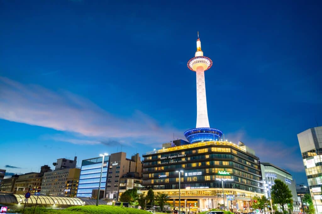 Kyoto Tower illuminated above Kyoto Station after sunset