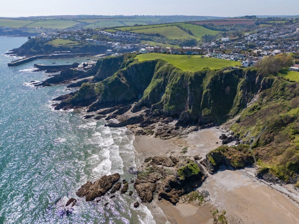 Aerial view of a Cornish coastal village surrounded by cliffs and countryside